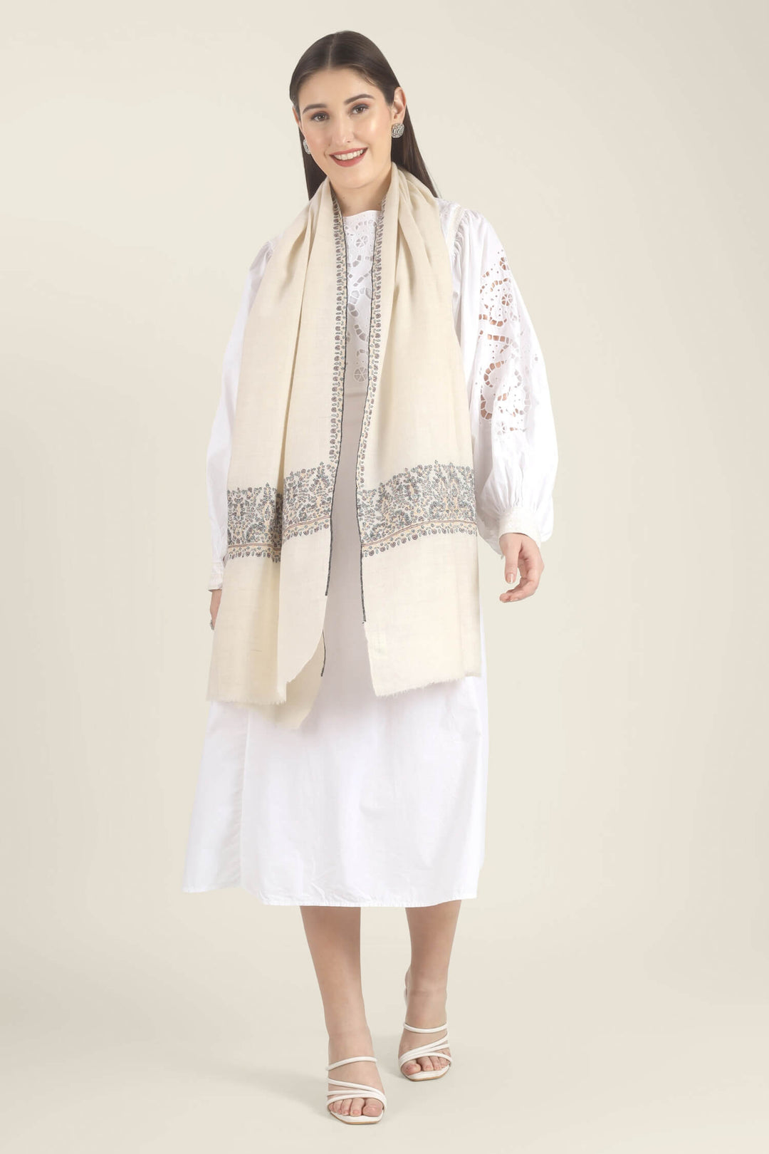 Model wearing a white GI Kashmiri Pure Pashmina stole with multicolour floral Sozni embroidered borders over a white outfit.