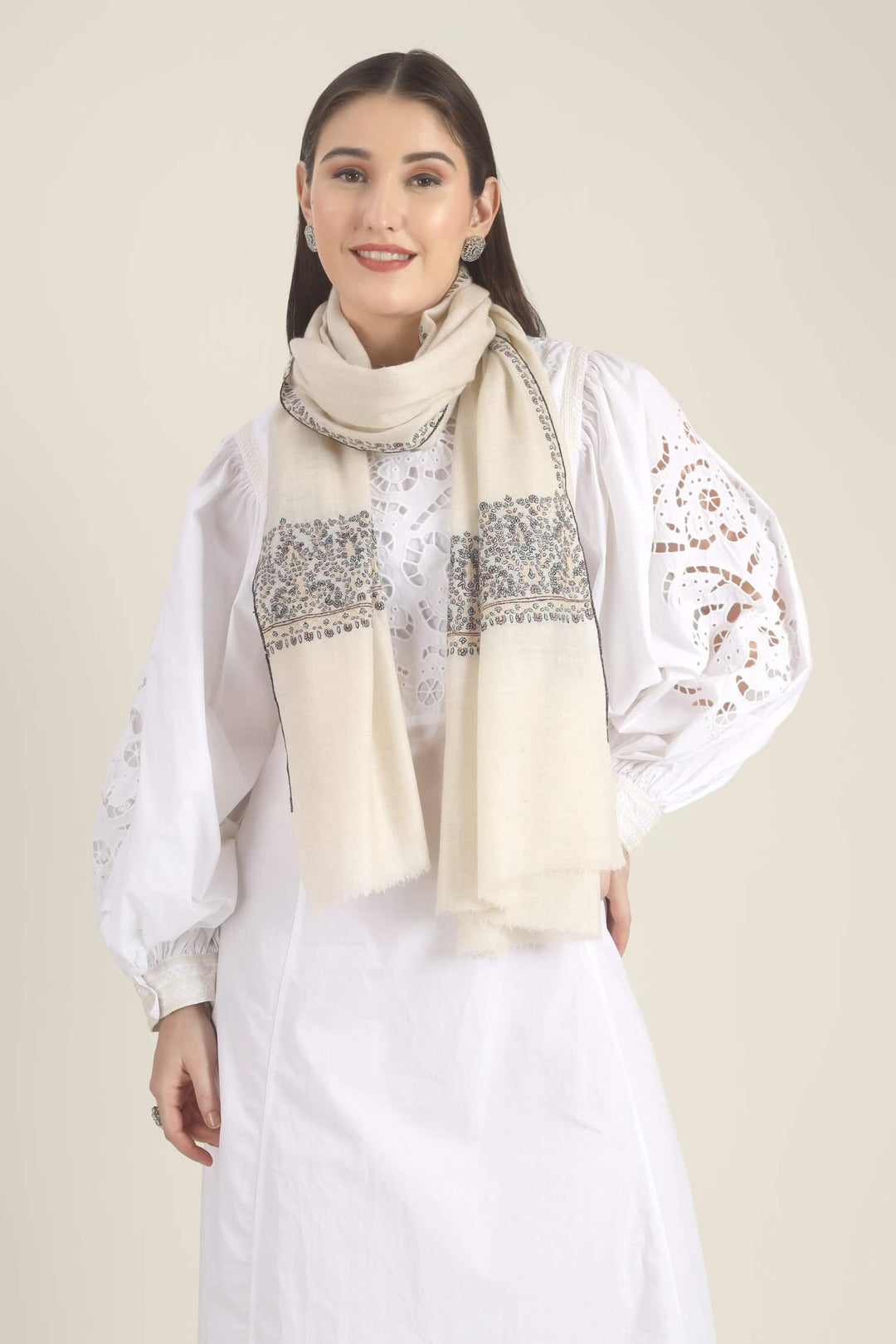 Model wearing a white GI Kashmiri Pure Pashmina stole with multicolour floral Sozni embroidered borders over a white outfit.