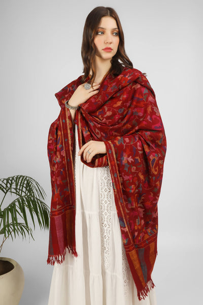  Redefine your dressing aesthetic with the luxurious wrap of a graciously handcrafted Kani Shawl which has no equal to it in all its detailed artistry and intricacies. The ravishing shade of Maroon plays home to the dancing florals and motifs in all the colors of nature skilled in the same splendid kani weave.