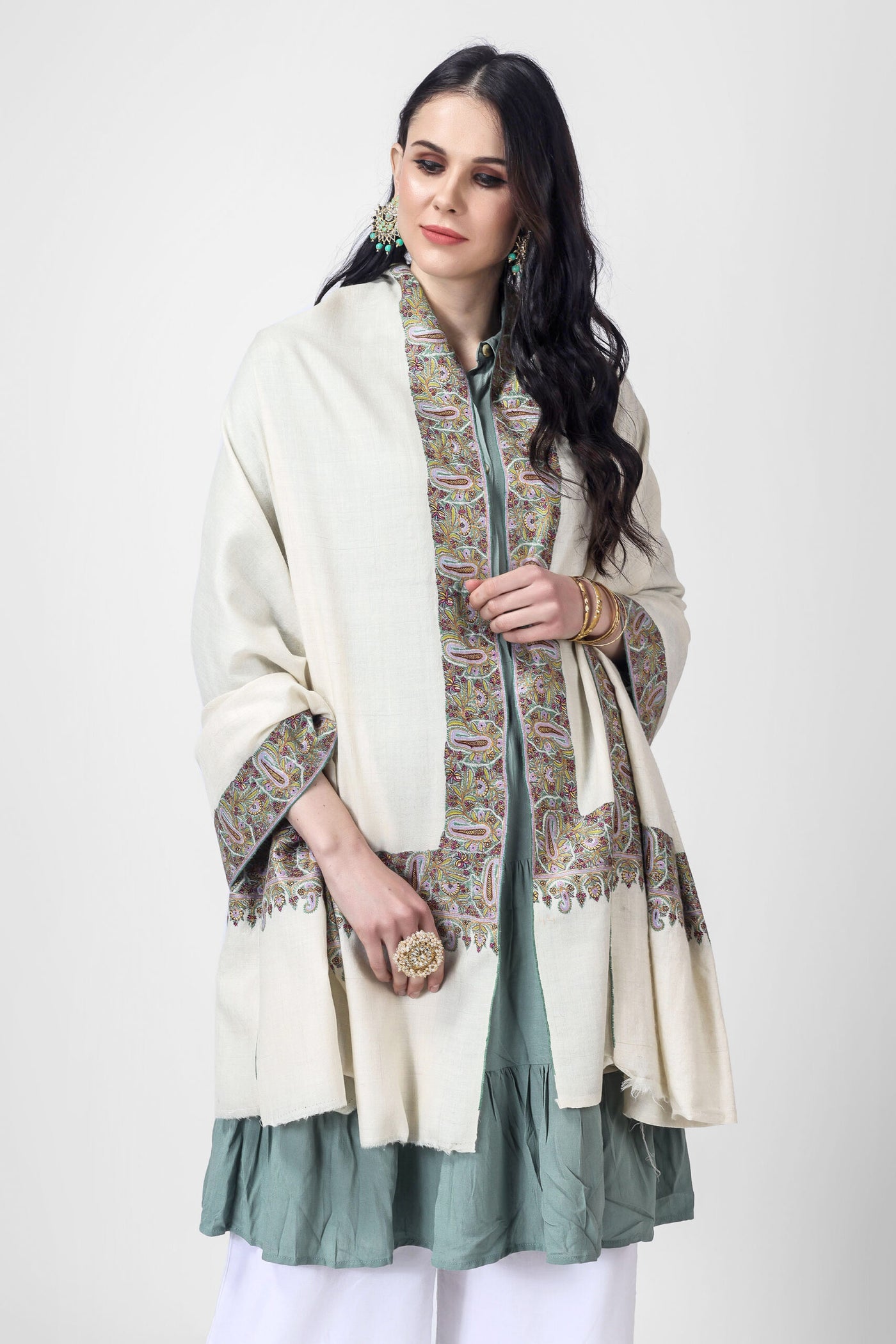 Drape yourself in luxury with a crafted Kashmiri pashmina shawl. This designer pashmina shawl will remain cozy and fashionable. It is created from the finest pashmina wool and features delicate almond shape stitching, making it the perfect addition to any event. On an off-white Pashmina shawl, 
