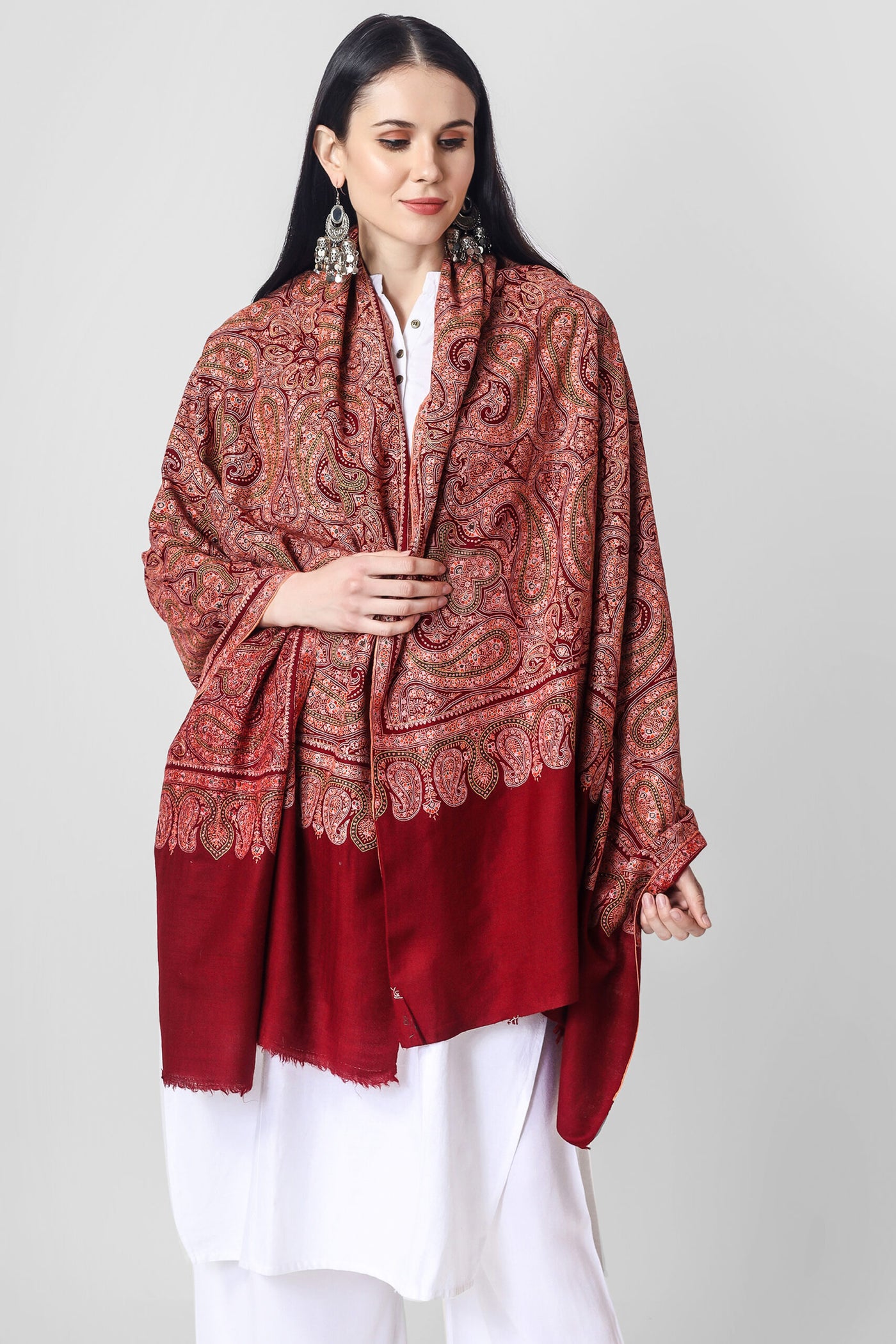 The Maroon Sozni Needlework Jama Pashmina shawl is a luxurious and elegant accessory that showcases the beautiful hand-embroidery tradition of the Kashmir region of India. 