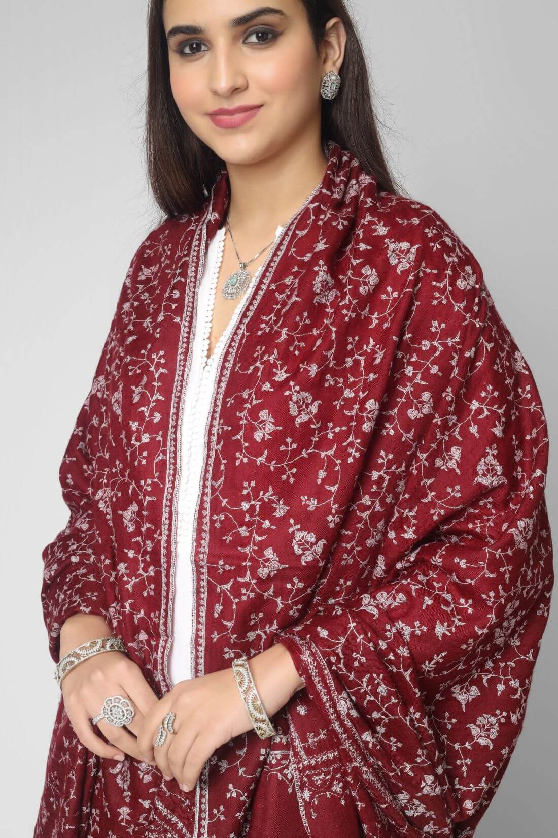 PASHMINA SHAWL - The embroidery is typically done by hand, using a needle and thread in shades of fade gray, which creates a beautiful and subtle contrast against the deep maroon color. The result is a stunning and sophisticated shawl that can be worn on special occasions or as a statement piece with any outfit.