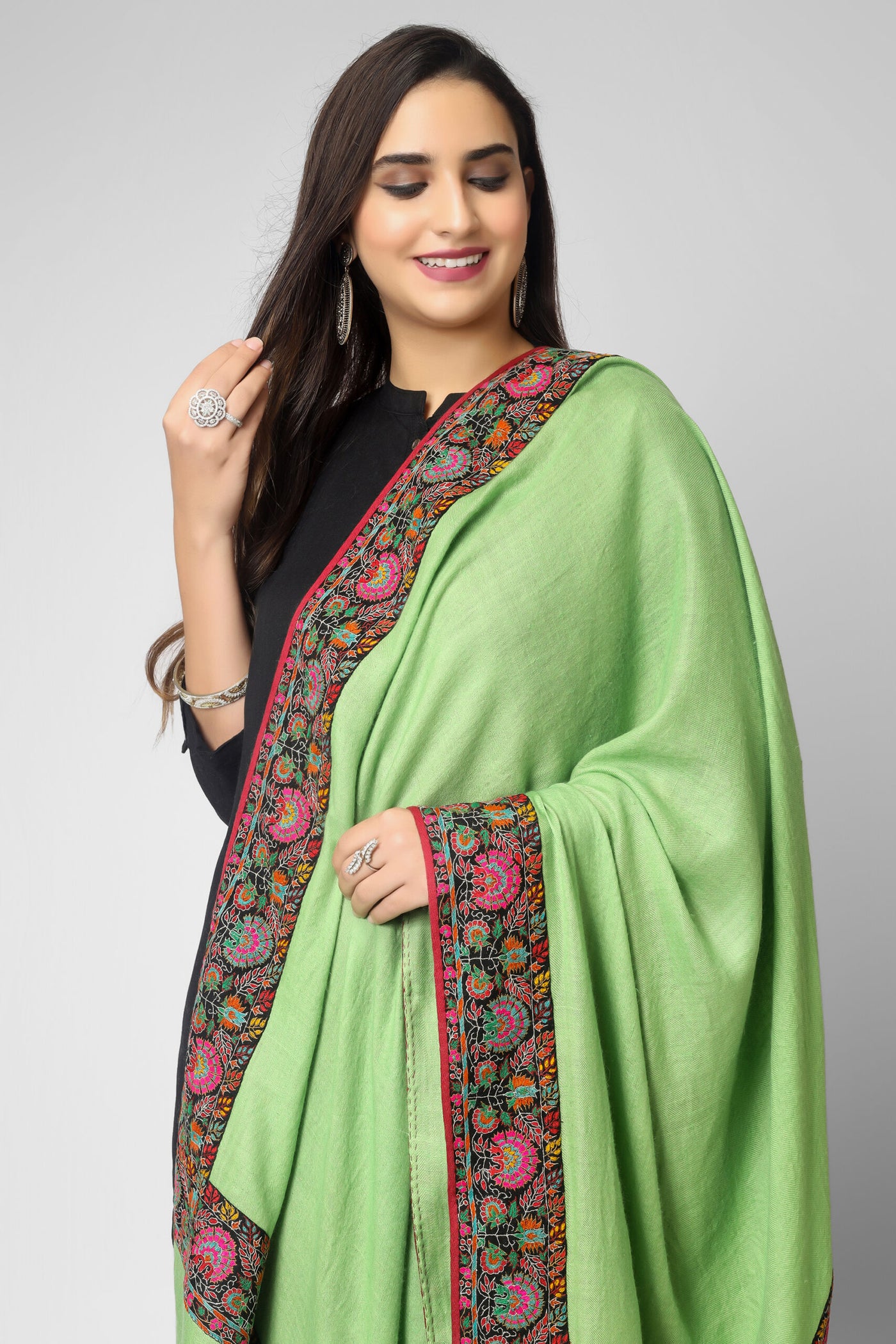  With this genuine Green Kashmiri pashmina shawl, made of the pashmina, you can swaddle yourself in luxury. It has beautiful embroidery and a lovely Doordaar design. A thick Sozni patchwork embroidered border surrounds the edges, exhibiting stunning designs created from tangled multicolor Sozni threads.