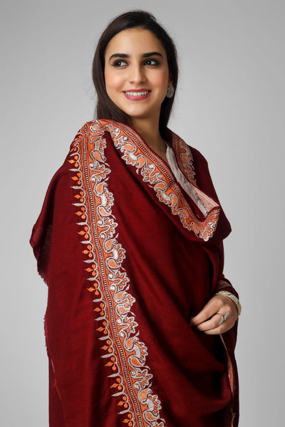 This handcrafted, intensely woven Maroon pashmina shawl features four borders that are evenly decorated with shimmering golden Tilla, a design known as the dourdaar pattern. You will feel both fashionable and traditional when wrapped in this exquisite shawl, which will also lend a touch of refinement to your outfit.