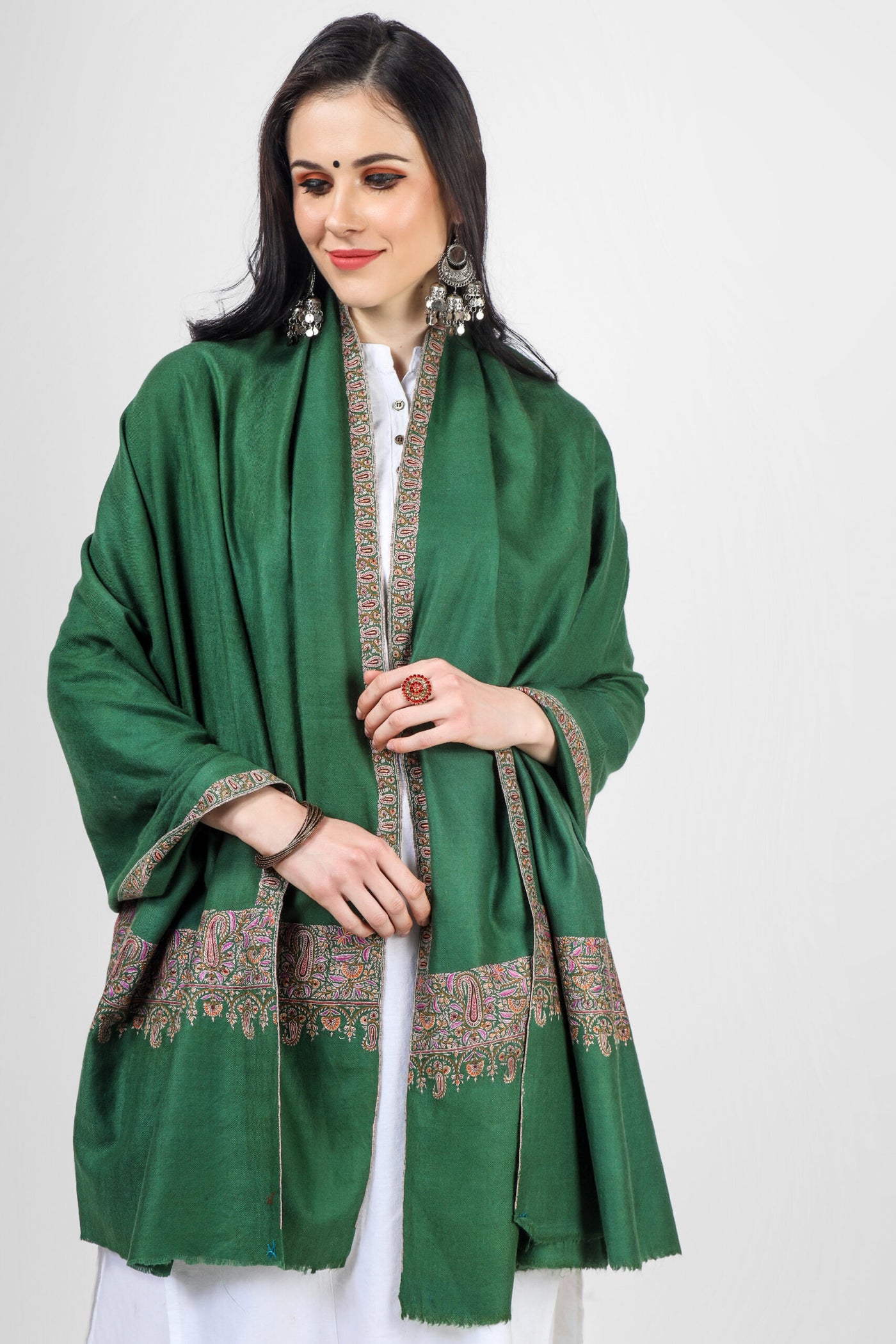 This green dourdaar with delicate needlework borders is done by experienced artisans . One of the most striking features of our Kepra  Kashmiri pashmina shawls is their intricate embroidery designs. These designs are inspired by traditional Indian shawls and feature everything from delicate floral patterns.