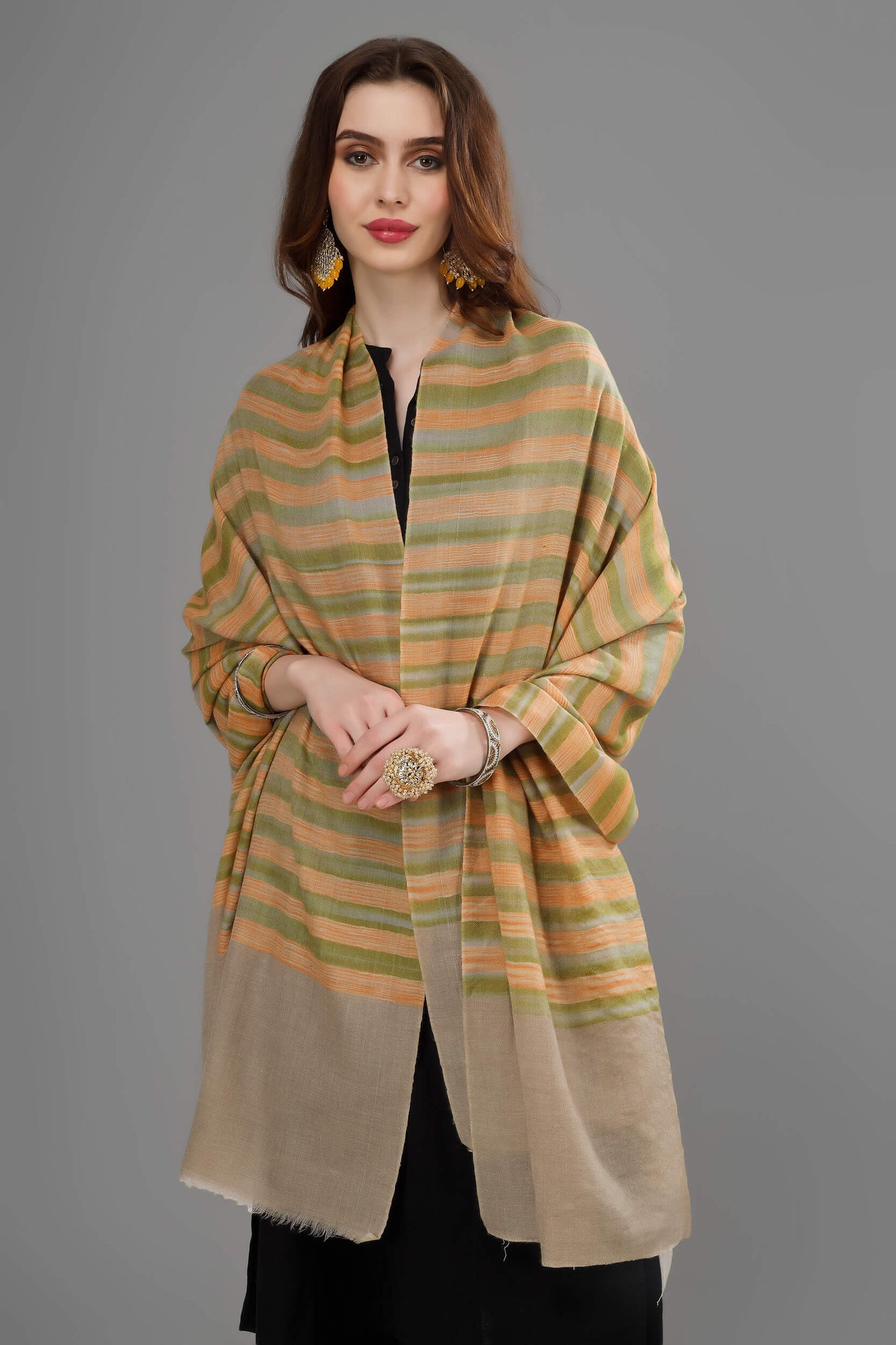 The handmade Kashmiri pashmina shawl, which is a favorite choice for bridal wear and is made of pure cashmere wool with stripes in yellow and green, is a luxurious winter accessory ideal for adding elegance to any outfit thanks to its colorful design.